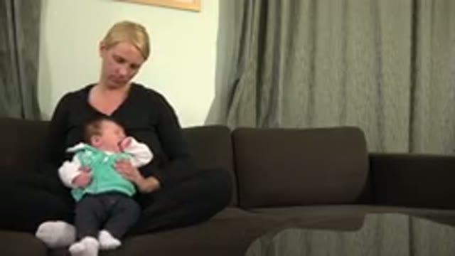 WESTMINSTER COLORADO-2015: A Mother Sitting On A Couch Holding Her Baby