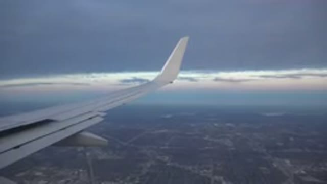 PLAYA DEL CARMEN MEXICO-2015: A Plane Flying Over The Sky With A City And Mountains
