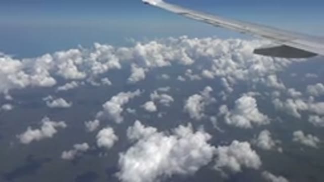 PLAYA DEL CARMEN MEXICO-2015: Flying Over A Partly Cloudy Sky In An Airplane