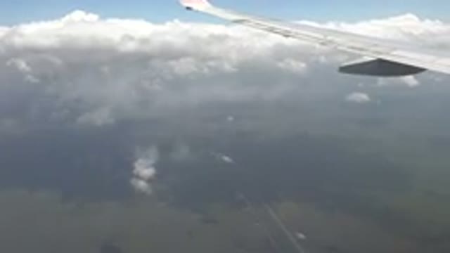 PLAYA DEL CARMEN MEXICO-2015: View From Airplane Window Of Wing Blue Sky Clouds