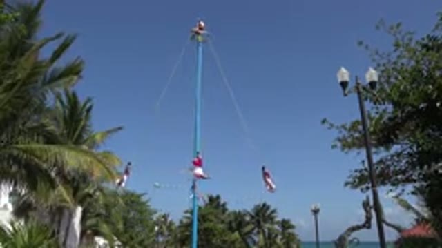 PLAYA DEL CARMEN MEXICO-2015: People Spinning Suspended by an Upside-Down Rope