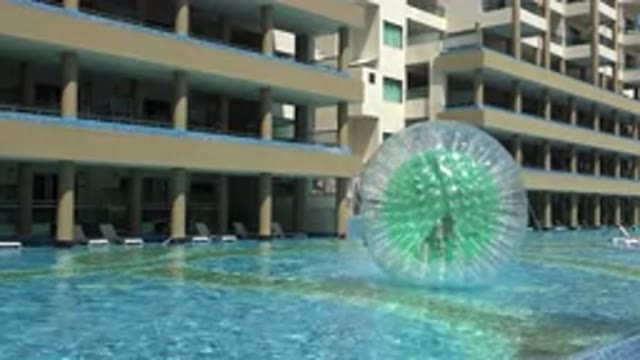 PLAYA DEL CARMEN MEXICO-2015: A Person Floating On An Inflatable Ball In A Pool
