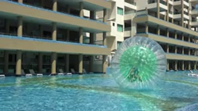 PLAYA DEL CARMEN MEXICO-2015: A Man Floating In A Pool Between Modern Buildings