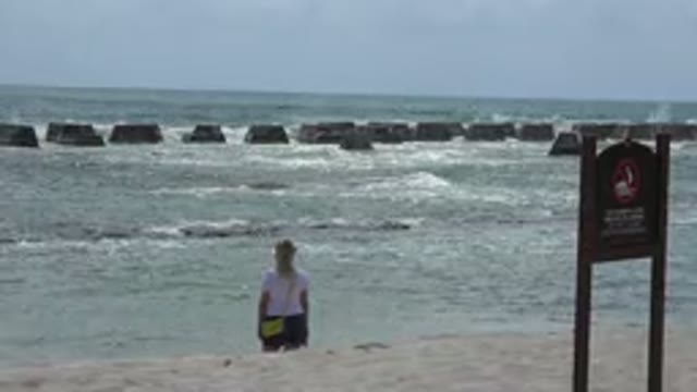 PLAYA DEL CARMEN MEXICO-2015: Blonde Woman With Yellow Bag Standing In Front Of Waves
