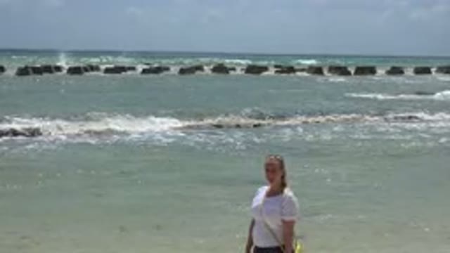 PLAYA DEL CARMEN MEXICO-2015: Woman Wearing White Shirt Stands Near Ocean Waves