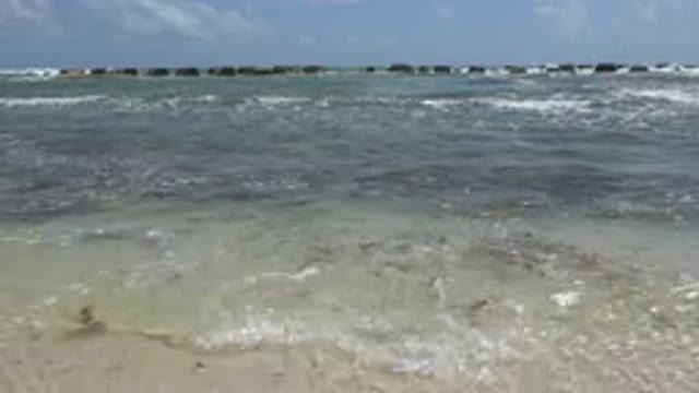 PLAYA DEL CARMEN MEXICO-2015: The Ocean Waves On The Beach Sand With Some Rocks