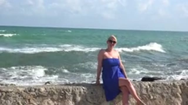 PLAYA DEL CARMEN MEXICO-2015: A Beautiful Lady Sitting On A Rock At The Beach
