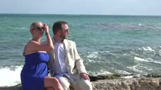 PLAYA DEL CARMEN MEXICO-2015: Couple Enjoying Nature Sitting On Rocks Facing The Sea