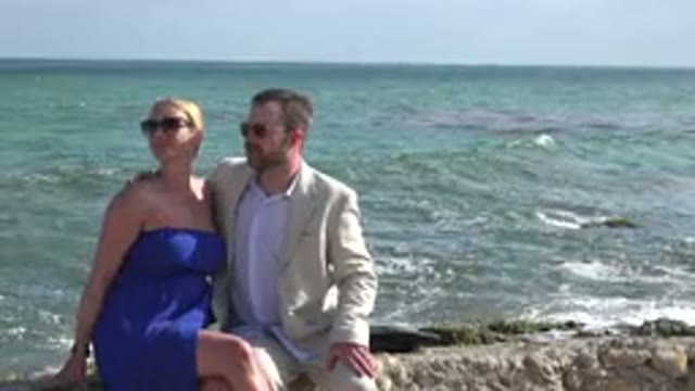 PLAYA DEL CARMEN MEXICO-2015: Man And Woman Observe Something Above Them While Sitting On Beach