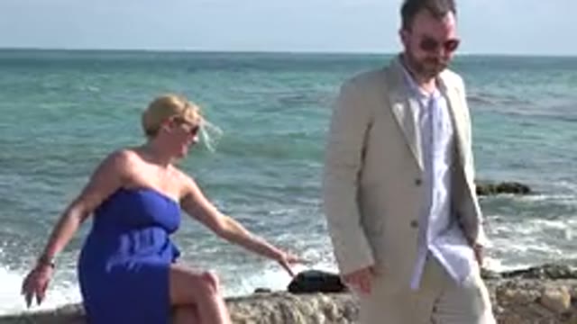 PLAYA DEL CARMEN MEXICO-2015: A Man And Woman Sit On Rocks And Promptly Get Up