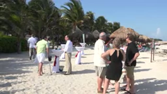 PLAYA DEL CARMEN MEXICO-2015: Men And Women Gather On Beach As Waiter Serves Drinks
