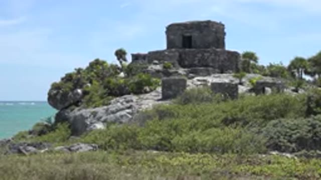 TULUM MEXICO-2015: Stone Temple Sitting On Top Of Rocky Hill Amid Jungle Vegetation