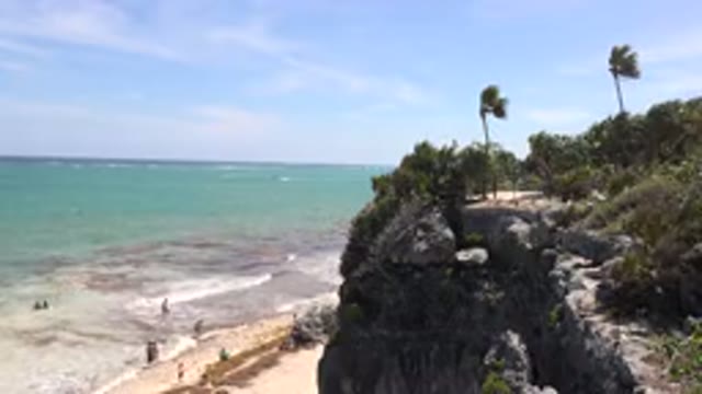 TULUM MEXICO-2015: A Group Of People Play At The Beach Below A Small Cliff