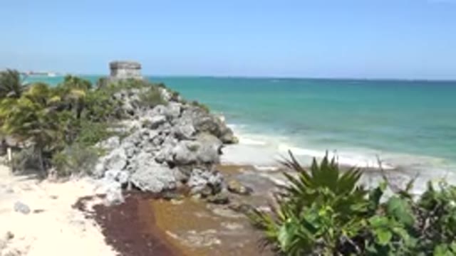 TULUM MEXICO-2015: Blue-Green Ocean Water Gray Rocks And Blue Sky On A Clear