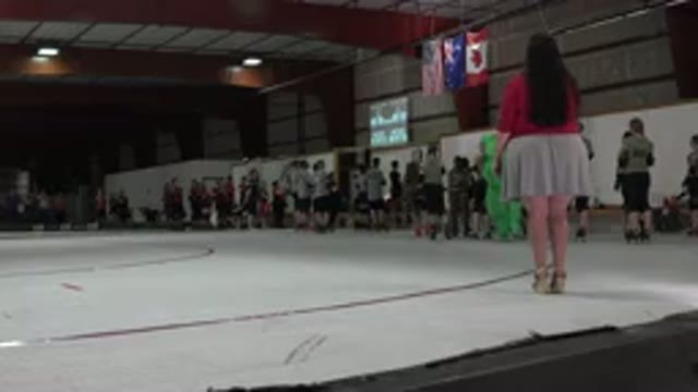 DENVER COLORADO-2015: Woman Wearing Red Shirt Stands On White And Red Roller Derby Rink