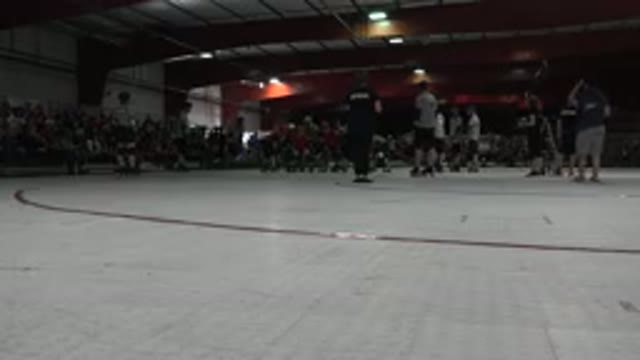 DENVER COLORADO-2015: Roller Derby Match Skaters and Referees on Rink with Camera Flashes