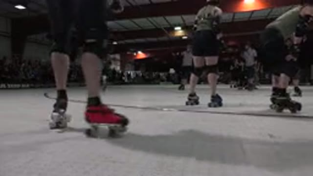 DENVER COLORADO-2015: Roller Derby Match Skaters And Referee Roll Around Rink