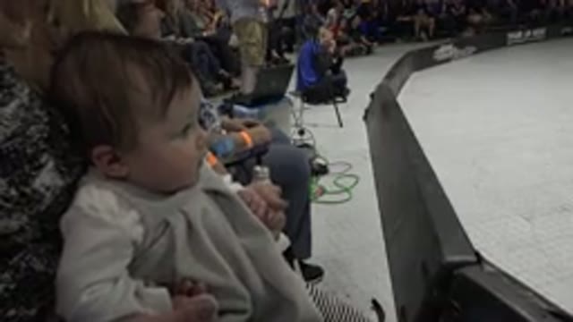 DENVER COLORADO-2015: Baby Girl in Mom's Lap Focused on Performers at Event