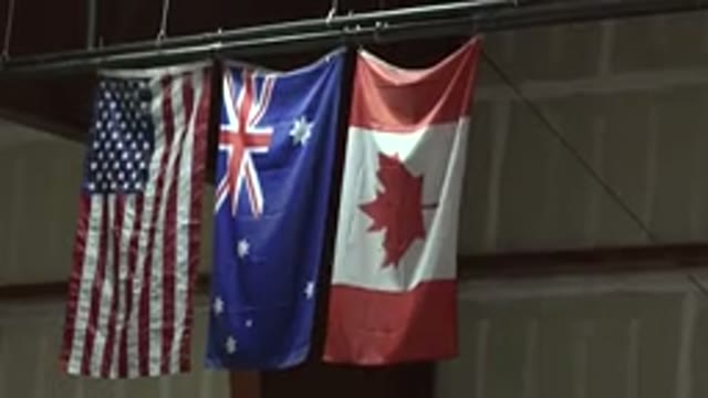 DENVER COLORADO-2015: Three Flags Stuck In The Top Of A School Stage While Man Walks