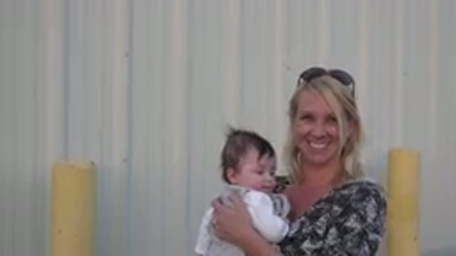 DENVER COLORADO-2015: Blonde Woman Holding And Swinging Child In Her Arms And