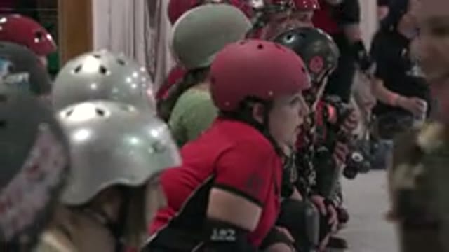 DENVER COLORADO-2015: Coach Instructs Skating Player Sitting on Ice