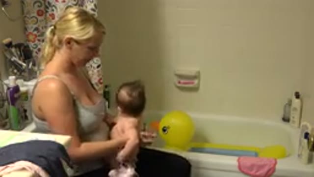 WESTMINSTER COLORADO-2015: A Blonde Woman Holds a Naked Baby in a Bathroom with a Yellow Duck