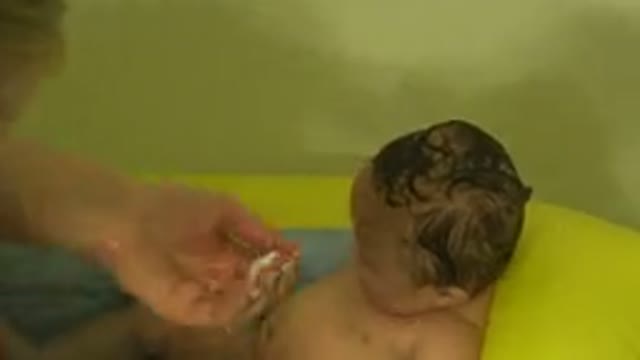 WESTMINSTER COLORADO-2015: A Blonde Woman Washing A Small Baby's Hair In The