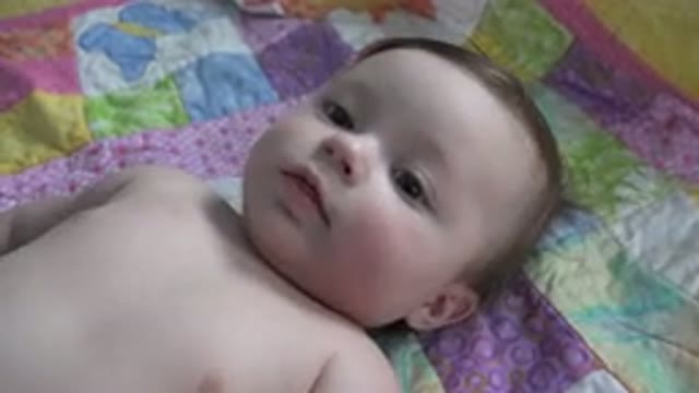 WESTMINSTER COLORADO-2015: Infant Lies On Purple And Pink Quilt Looking At
