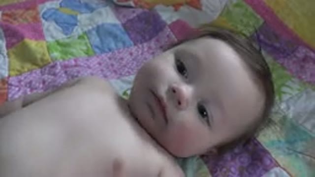 WESTMINSTER COLORADO-2015: Cute Baby Playing And Looking At The Camera Lying On Bed