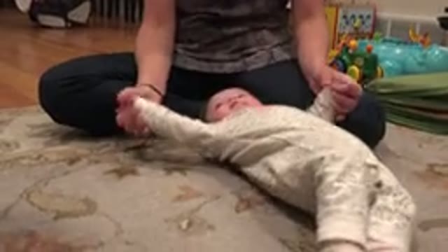 WESTMINSTER COLORADO-2015: Mother Stretches Baby's Limbs Lying on Floor