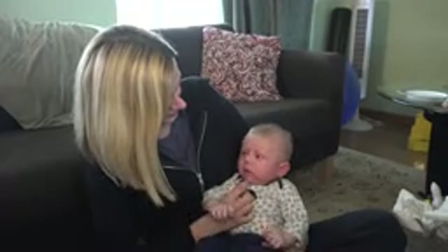 HIDDEN LAKE COLORADO-2015: Blonde Woman Sitting On Floor With Child In Her Arms