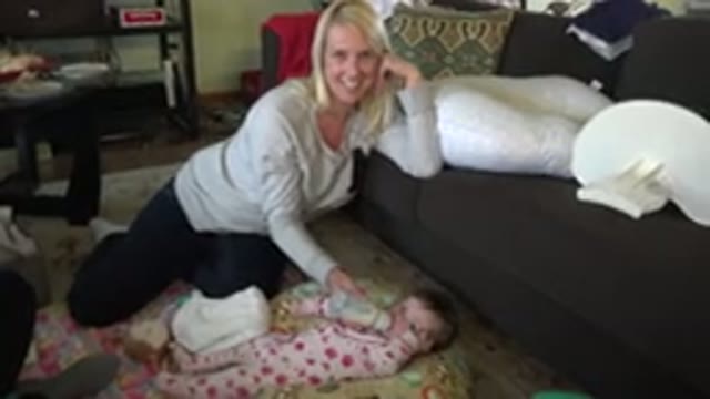 HIDDEN LAKE COLORADO-2015: Mother Bottle Feeding Her Infant Child While Sitting