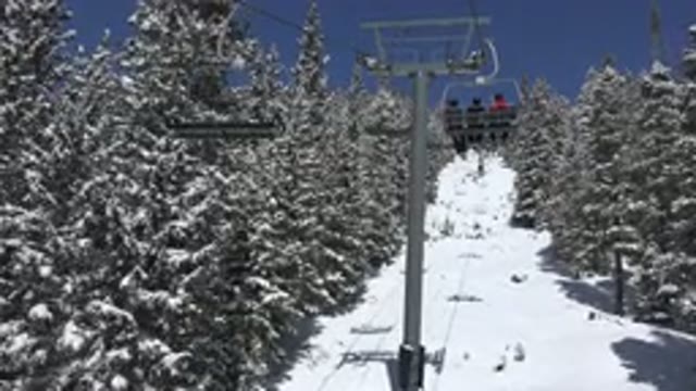 KEYSTONE COLORADO-2015: People Riding A Chair Lift At A Ski Resort In Trees