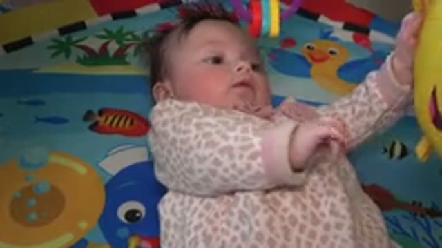 WESTMINSTER COLORADO-2015: A Baby With Brown Hair Laying On Her Back On A Play Mat
