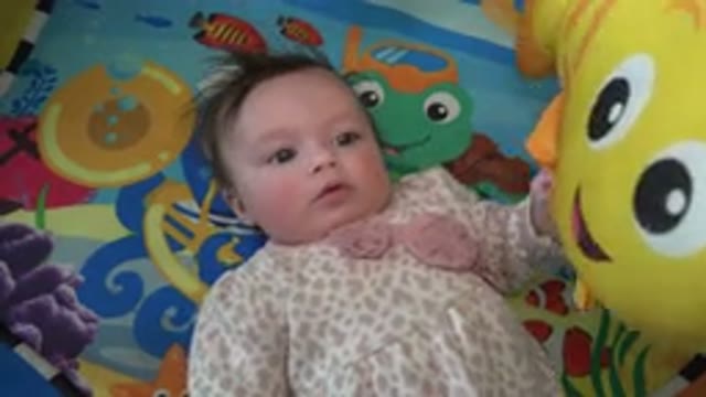 WESTMINSTER COLORADO-2015: Baby Lying in Bed Restless Holding Yellow Fish Shaped Balloon