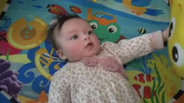 WESTMINSTER COLORADO-2015: Baby Wearing Pink And White Sleeper Looks At Stuffed Toy