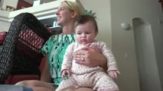 WESTMINSTER COLORADO-2015: Woman Wearing Green Shirt Holds Baby Wearing Pink And White