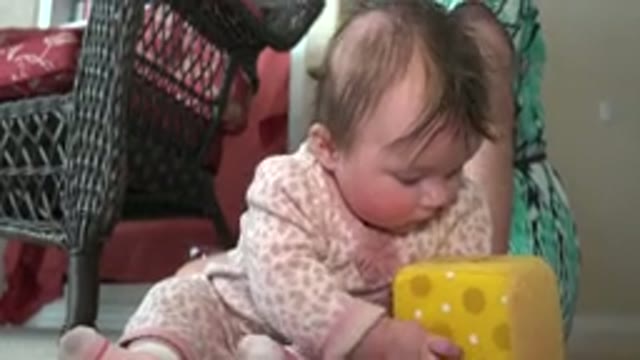 WESTMINSTER COLORADO-2015: Baby Wearing Pink And White Sleeper Looks At Stuffed Toy