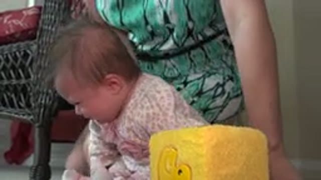 WESTMINSTER COLORADO-2015: Woman Wearing Green Dress Picks Up Baby Wearing Pink