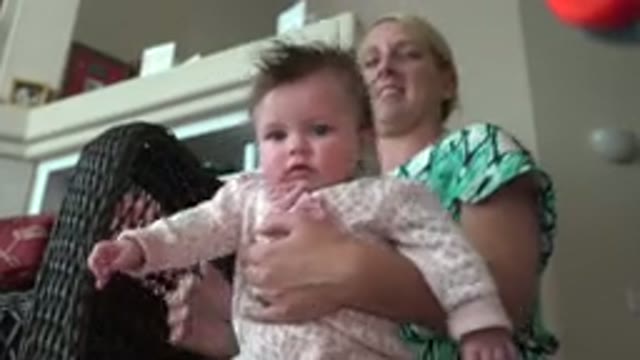 WESTMINSTER COLORADO-2015: Woman Wearing Green Shirt Holds Baby Wearing Pink And