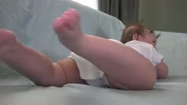 WESTMINSTER COLORADO-2015: Baby Wearing White Kicking His Feet On A Sheet