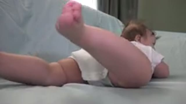WESTMINSTER COLORADO-2015: Baby Wearing White Shirt Lies on Green Sofa Kicking