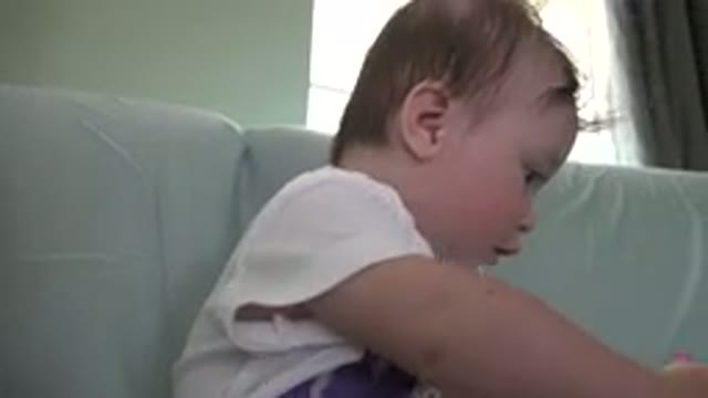 WESTMINSTER COLORADO-2015: Baby Wearing White and Purple Shirt Sits on Light Sofa