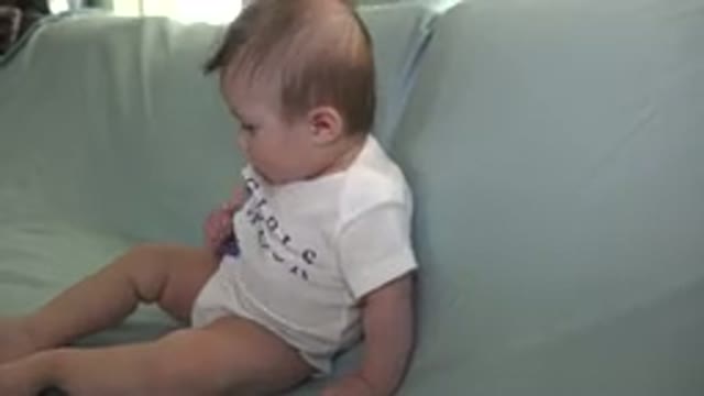 WESTMINSTER COLORADO-2015: Baby Wearing White and Purple Shirt Sits on a Sofa