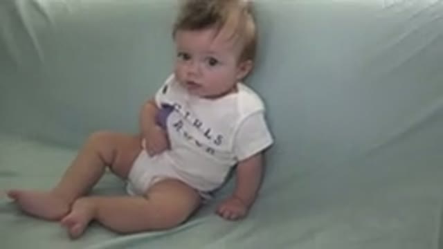 WESTMINSTER COLORADO-2015: Baby Wearing White Shirt Sits On Green Sofa