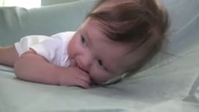 WESTMINSTER COLORADO-2015: Baby Chewing On Own Fingers And Kicking Feet On Blue Couch