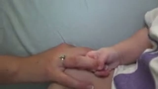 WESTMINSTER COLORADO-2015: Infant in White and Purple Jumpsuit Holding Adult's Finger