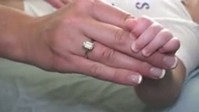 WESTMINSTER COLORADO-2015: Woman Changing Baby's Diaper While Infant Squirms