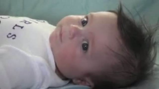 WESTMINSTER COLORADO-2015: Baby Wearing White Shirt Lies On Light Green Blanket