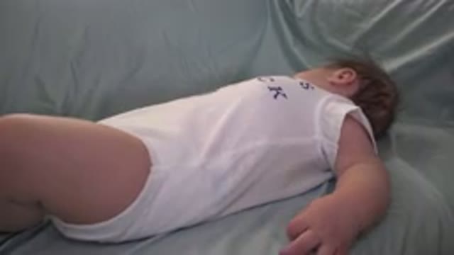 WESTMINSTER COLORADO-2015: A Baby With Blond Hair in White Rompers Lying and Moving Arms and Legs